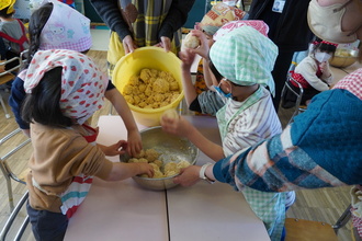 大豆を容器につめる園児たちの写真